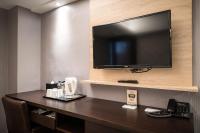 a flat screen tv on a wall in a hotel room at Global Traveler Hotel in Kaohsiung