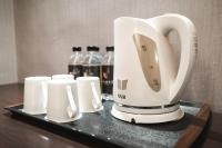 a white coffee maker and cups on a tray at Global Traveler Hotel in Kaohsiung
