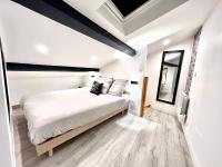 a bedroom with a bed with white sheets and a mirror at Le Loft ~ à 4 min de la gare, Fibre + Parking privé in Poitiers