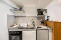 a small kitchen with a sink and a microwave at Maison atypique dans circulade in Bram
