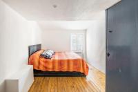 a bedroom with a bed with an orange blanket at Maison atypique dans circulade in Bram
