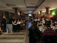 un gruppo di persone sedute ai tavoli di un ristorante di Gondola lift apartment a Bansko