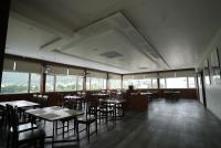 Un comedor con mesas y sillas y ventanas. en HOTEL SUNRISE HOSPITALITY, en Vijayawāda