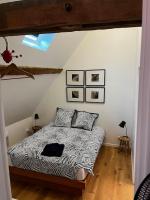 a bedroom with a bed with a black and white comforter at Gîte des 3 Marchands in Buzançais