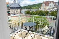a balcony with a table and chairs and a view of a city at 2 pièces Port Cabourg - 2 à 4 personnes - 34 m2 - Balcon - Vue Port - Nouveau sur Booking ! in Dives-sur-Mer