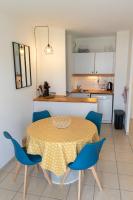 a kitchen with a table and blue chairs in a room at 2 pièces Port Cabourg - 2 à 4 personnes - 34 m2 - Balcon - Vue Port - Nouveau sur Booking ! in Dives-sur-Mer