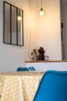 a kitchen with a counter with two blue chairs at 2 pièces Port Cabourg - 2 à 4 personnes - 34 m2 - Balcon - Vue Port - Nouveau sur Booking ! in Dives-sur-Mer