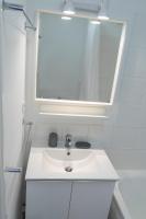 a white bathroom with a sink and a mirror at 2 pièces Port Cabourg - 2 à 4 personnes - 34 m2 - Balcon - Vue Port - Nouveau sur Booking ! in Dives-sur-Mer