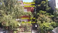 a sign on the side of a building with trees at Apartmani Mimi in Soko Banja