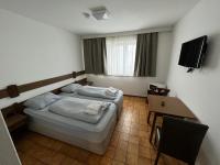 a bedroom with a bed and a table and a television at F Hotel in Hörsching