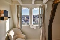 a room with a chair and a window with a view at La Demeure du Clocher 4 - On the Port and Place St Catherine - 8 P in Honfleur