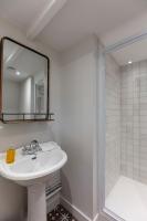 a white bathroom with a sink and a mirror at La Demeure du Clocher 4 - On the Port and Place St Catherine - 8 P in Honfleur