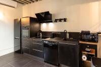 a black kitchen with a sink and a microwave at La Demeure du Clocher 4 - On the Port and Place St Catherine - 8 P in Honfleur