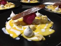 Un postre con un cuchillo en un plato negro. en Les Rêves de Baie de Somme Chambres d'hôtes , Table d'hôtes et Spa, en Béhen