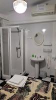 a white bathroom with a sink and a shower at Pensión San Benito Abad in Seville