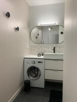 a bathroom with a washing machine and a sink at Champagne! Appartement spacieux Reims centre in Reims