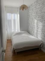 a small bedroom with a bed with a window at Champagne! Appartement spacieux Reims centre in Reims