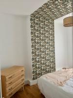 a bedroom with a bed and a dresser and a wall at Champagne! Appartement spacieux Reims centre in Reims