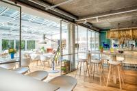 un ristorante con tavoli e sedie bianchi e grandi finestre di Fettehenne Gästehaus a Erkrath