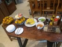 Una mesa con cuencos de fruta y platos encima. en Anantaya Home, en Phrae