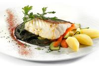 a plate of food with a piece of fish and vegetables at HCC Montblanc in Barcelona