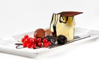 un dessert su un piatto bianco con frutta di HCC St. Moritz a Barcellona