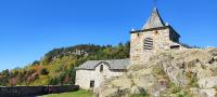 an old stone church with a steeple on a mountain at Bulle de Bois, écolodge insolite avec spa privatif au milieu des volcans - Bulles d&#39;Herbe in Queyrières