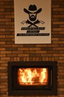 een bord boven een bakstenen open haard met een brandend vuur bij СИТИЙ КОВБОЙ in Leznevo