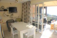 a living room with a white table and a balcony at appartement pour 6 personnes cap esterel in Saint-Raphaël