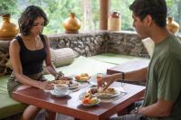 Kuru Ganga Villa في Eratnagoda: يجلس رجل وامرأة على طاولة لتناول الطعام