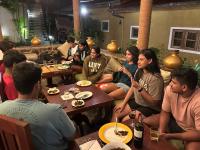 Kuru Ganga Villa في Eratnagoda: مجموعة من الأشخاص يجلسون على الطاولات في مطعم