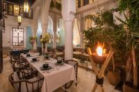 a restaurant with white tables and chairs and a candle at Riad Dar Saad - Hammam & Spa in Marrakech