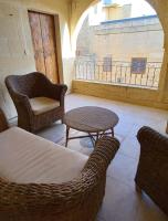 a living room with chairs and a table and a window at Ta Majsi farmhouse with indoor heated pool in San Lawrenz
