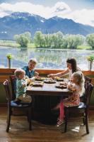 eine Familie, die am Tisch sitzt und Essen isst in der Unterkunft Ninepipes Lodge in Polson