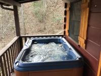 einen Whirlpool auf einer Veranda mit einem Fenster in der Unterkunft Dollywood! Brand new Dancing Bear 3-Bear Tracks in Pigeon Forge