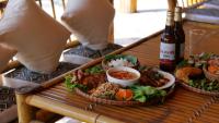 a table with a tray of food and a bottle of beer at Nha Tan - Mai Chau Homestay & Tours in Mai Châu