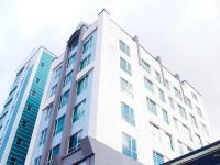 un edificio alto de color blanco con muchas ventanas en Swiss Hotel Apartment, en Kuala Belait