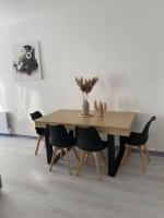 a wooden table and chairs in a room at Appartement Moderne Saint-Gaudens in Saint-Gaudens