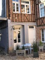 a building with a table and benches in front of it at Le Logis de Pélagie in Neufchâtel-en-Bray