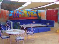 a room with a blue couch and chairs and a table at Auberge Triskell in Nouakchott