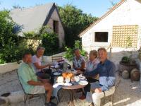 a group of people sitting around a table with food on it at Chambres d&#39;Hôtes L’Échappée Belle in Saint-Brisson-sur-Loire
