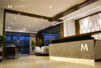 a lobby with a m logo on the wall at Madero Hotel &amp; Suites in La Paz