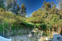 a patio with a table and chairs under an umbrella at Cortijo La Hoya in El Bujeo