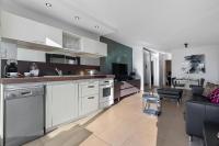 a kitchen with white cabinets and a living room at Village Naturiste R4N - Le Cassis Heliopolis Luxe in Cap d&#39;Agde