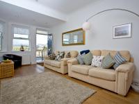 a living room with two couches and a rug at Quay House, Porth Beach in Saint Columb Minor