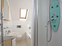 a white bathroom with a shower and a sink at Quay House, Porth Beach in Saint Columb Minor