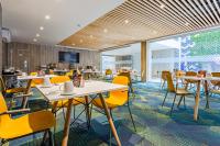 a dining room with tables and yellow chairs at KALI Centro Mexico City in Mexico City