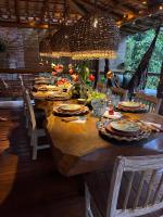 een grote houten tafel met stoelen en een grote kroonluchter bij Locanda Ariramba in Santa Cruz Cabrália
