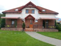 a house with a green lawn in front of it at Apartmany Svaty Kriz in Liptovský Mikuláš