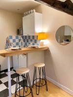 a kitchen with a counter and stools in a room at Charmant studio au coeur de Blois in Blois